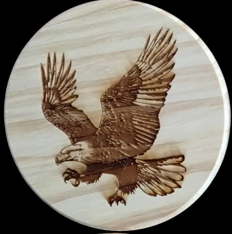 A wooden coaster featuring an intricately carved eagle design, showcasing craftsmanship and nature's beauty.